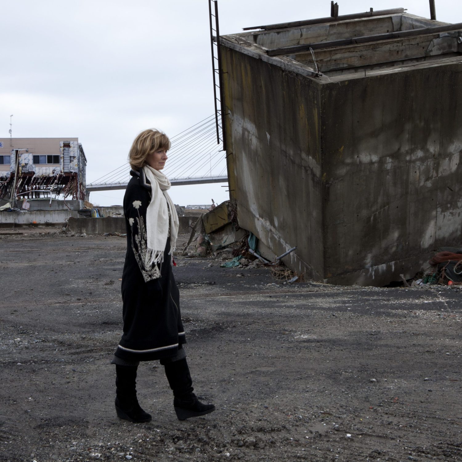 Adi Roche of Chernobyl Children International walking by destroyed buildings seaside in Soma City, Fukushima Prefecture